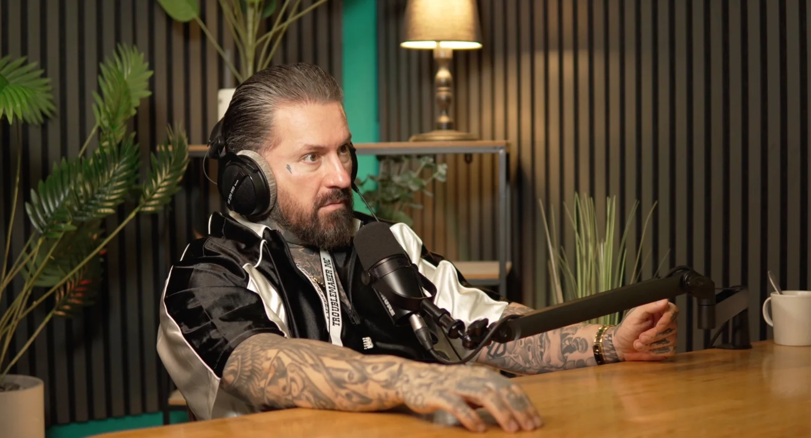 Gast im Gespräch am Mikrofon im Podcaststudio